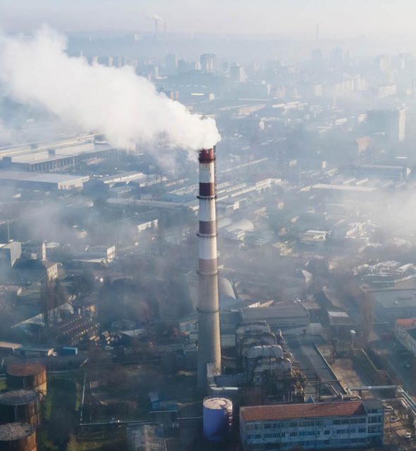 Aerial drone view of Chisinau. Thermal station with smoke coming out of the tube. Buildings and roads. Fog in the air. Moldova